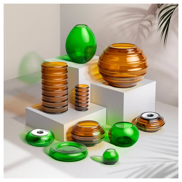 Colorful recycled glass vases in green and brown, varied shapes on white pedestals, some with metallic accents.