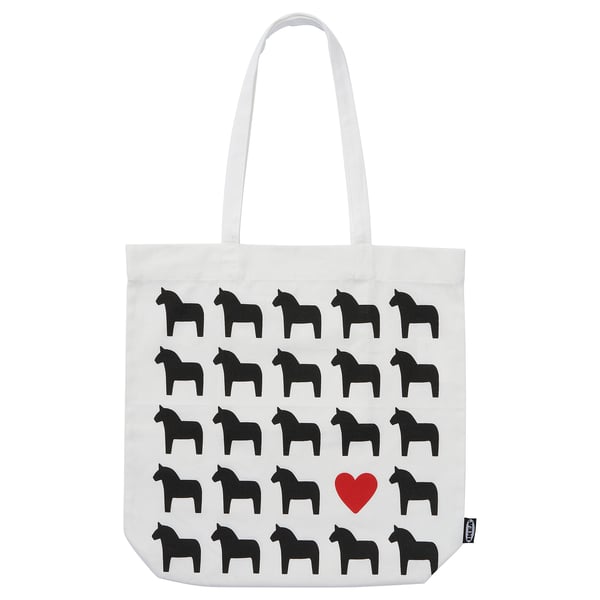 This image a white tote bag named HÄSTHAGE with black dala horse prints and a red heart, made of cotton.