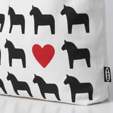 A fabric bag with black horse and red heart prints, highlighting its quality and design.