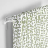 Geometric green-white curtains hang from a white rod, filtering light and providing privacy with a patterned design.