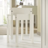 White HAUGA drop-leaf table with wooden legs; compact, versatile for small spaces.