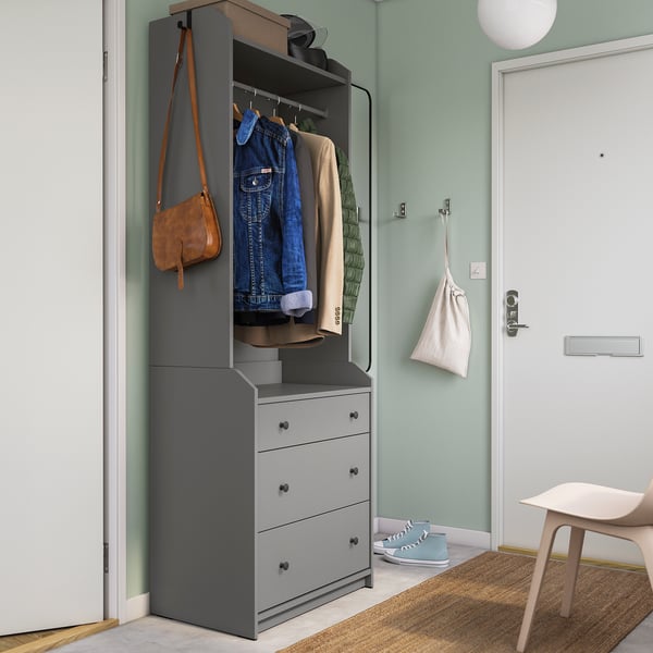 Modern grey HAUGA wardrobe with drawers, hangers, & hooks, featuring jean jacket, bag, & sneakers, set against sage walls.