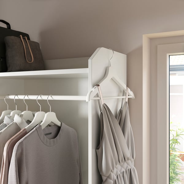 Closet with gray clothes hangers and shelf with bag.