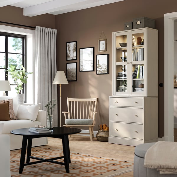 Modern living room with HAVSTA cabinet, rocker, coffee table, books, plants, and art.