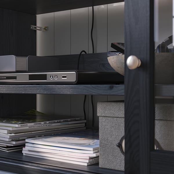 A sectional wooden shelf unit with glass doors in a home office.