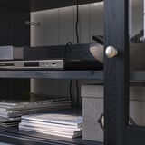 A sectional wooden shelf unit with glass doors in a home office.