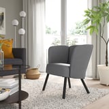 Modern gray HERRÅKRA armchair with black legs in living room.