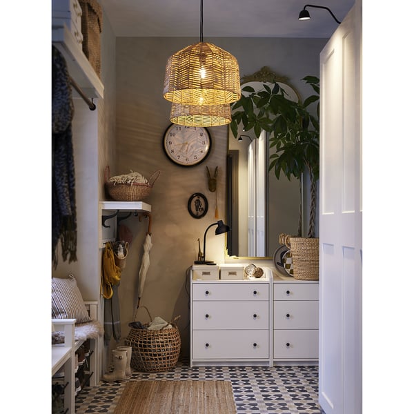 Room with white dresser, mirror, and hanging light. Large basket on wall, small yellow one beside. Plant on dresser. Earthy, natural decor.