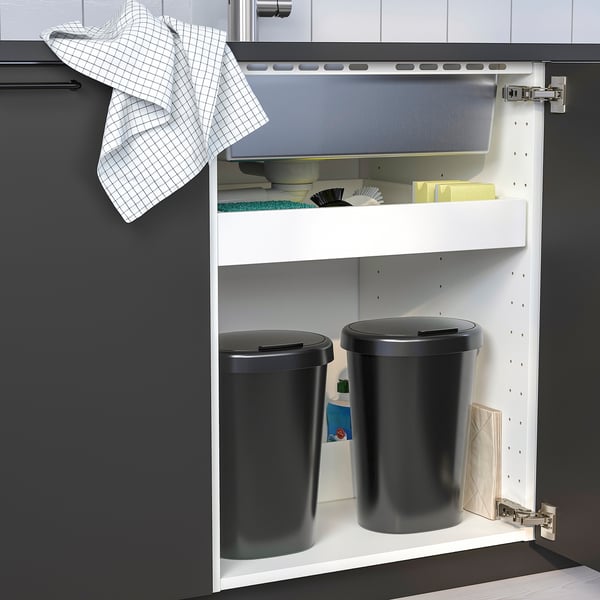 Kitchen cabinet with two trash bins for wet and dry waste, one with a lid.