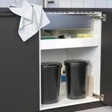 Kitchen cabinet with two trash bins for wet and dry waste, one with a lid.