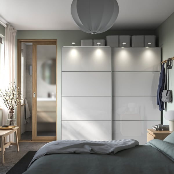 Modern bedroom with grey HOKKSUND sliding wardrobes, wooden accents, and minimalist decor.