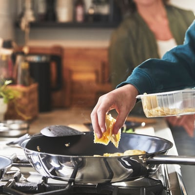 A person pours batter into a non-stick skillet, showcasing easy cooking and cleaning.
