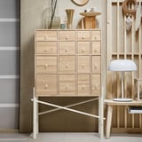 IKEA PS SINKA cabinet, light wood, modern design. Multiple drawers, clean lines, stylish handles, white legs, and minimalist decor.