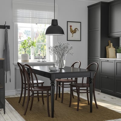 Modern dining area with INGATORP table, black decor, plant.