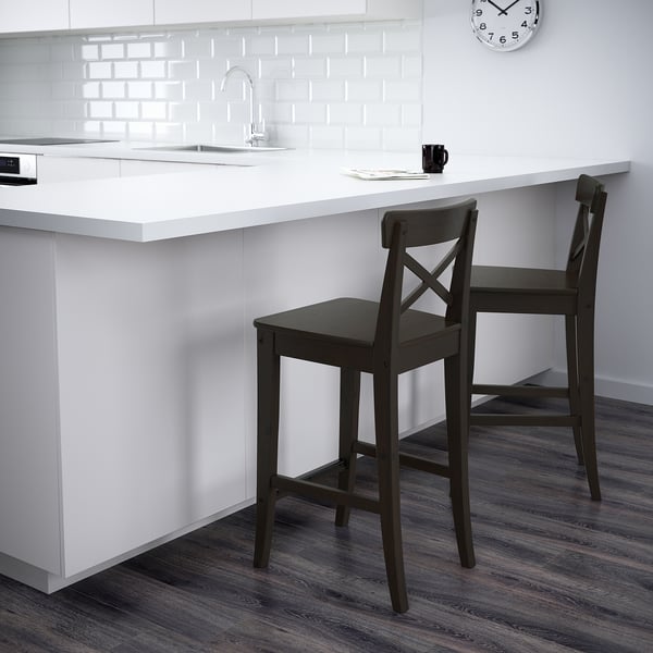 Dark wood bar stools with backs at white kitchen island.