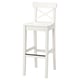 An INGOLF white bar stool with a simple, white, wooden design. It has a backrest with an x shape and a footrest for comfort.