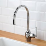 Modern kitchen faucet with chrome finish and white lever. Automatic water flow via sensor technology.