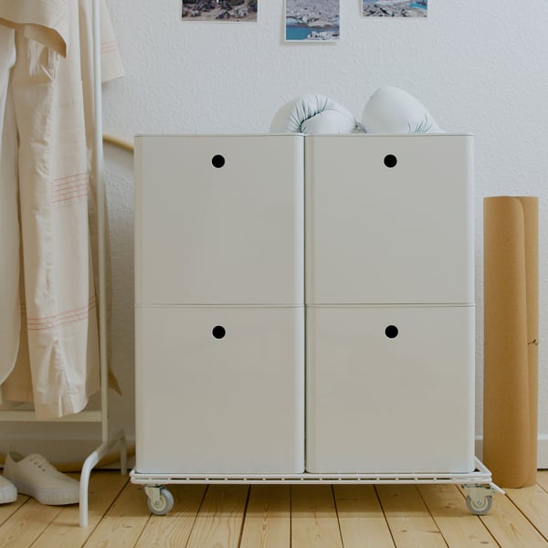 White storage trolley with four drawers and wheels on wooden floor.