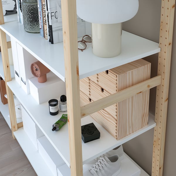 Wooden storage shelves with lamp, clock, books, and sneakers.