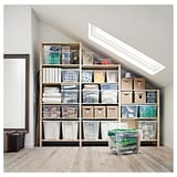 Attic with IVAR shelves filled with organized storage bins; clear, beige, and green containers on wooden shelves.
