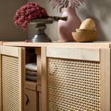 IVAR cabinet with woven bamboo doors, light wood color, storage shelves, and decorative items on top.