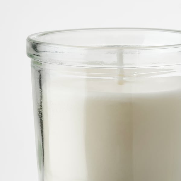 Glass candle jar with white candle, condensation for purity.