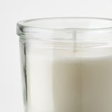 Glass candle jar with white candle, condensation for purity.