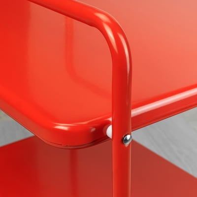 Close-up of vibrant red metal chair joint. Shows smooth, even finish and secure fastener.