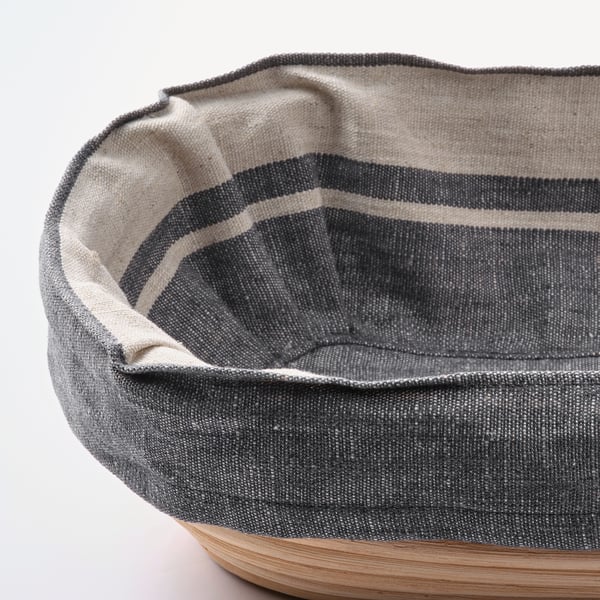Retted fabric basket with gray and white stripes, neatly placed on a clean, white surface.