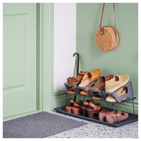 Green entryway with shoe rack, shoehorn, purse, rug, tiles