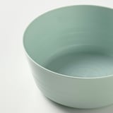 Light green plastic bowl with smooth sides and a wide base, shown in close-up.
