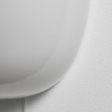 Sleek, modern wall lamp with smooth, mouth-blown glass shade, casting soft light. High-quality design with a touch of elegance.