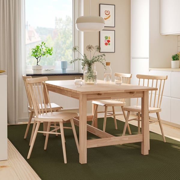 KARSKÄR dining set: light wood table extends, four spindle-back chairs, placed beneath large window. Modern scandinavian design.
