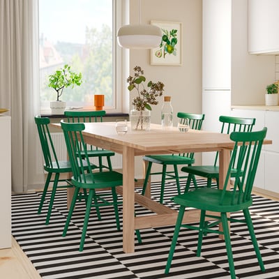 Dining area with green KARSKÄR chairs, extendable table, and floral vase.