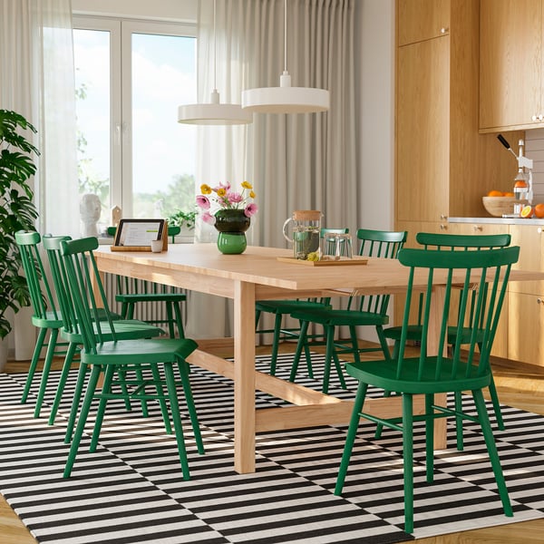 Modern dining room with KARSKÄR table, chairs, and large windows. Centred vase, glasses, and pitcher. Scandinavian style.