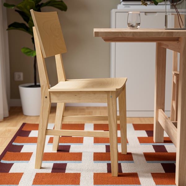 Wooden chair and table on rug. Durable, versatile for home or public use. Table extends for gatherings.