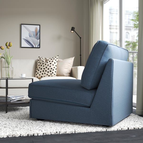 Blue KIVIK sofa-bed in modern living room. Converts for guests, decorated with pillows and flowers.