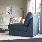 Blue KIVIK sofa-bed in modern living room. Converts for guests, decorated with pillows and flowers.