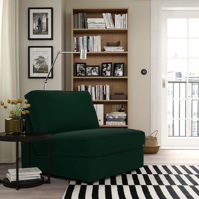 KIVIK dark green compact sofa-bed near a bookshelf, fitting well in small space.