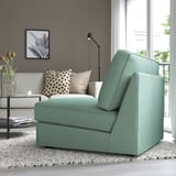 Modern living room with green KIVIK sofa-bed by window, coffee table & vase, polka dot bench.