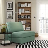 Cozy green KIVIK sofa-bed, compact for small spaces, by large bookcase and window.