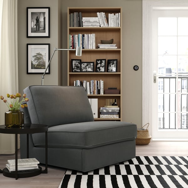 Grey KIVIK sofa-bed in cozy room, perfect for small spaces with modern design.