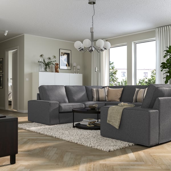 Modern living room with KIVIK sectional sofa, wooden floors, and big windows.
