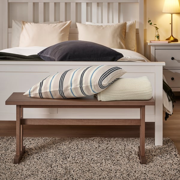 KLIMPFJÄLL wooden bench in bedroom with pillows, under bed, next to nightstand.