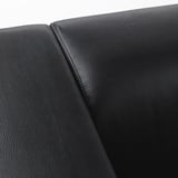 Close-up of sleek, high-quality black sofa armrest, smooth texture and neat stitching visible.