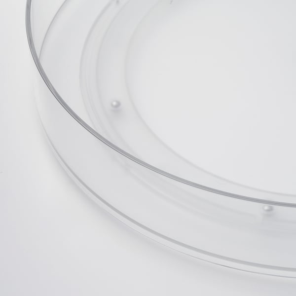 Clear, circular storage organizer with raised edges, designed for easy rotation. Made of durable plastic.