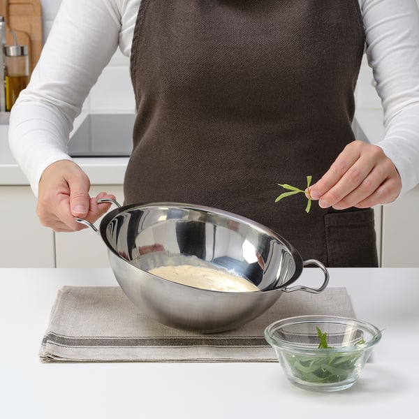 Melting food in double boiler, herbs nearby.