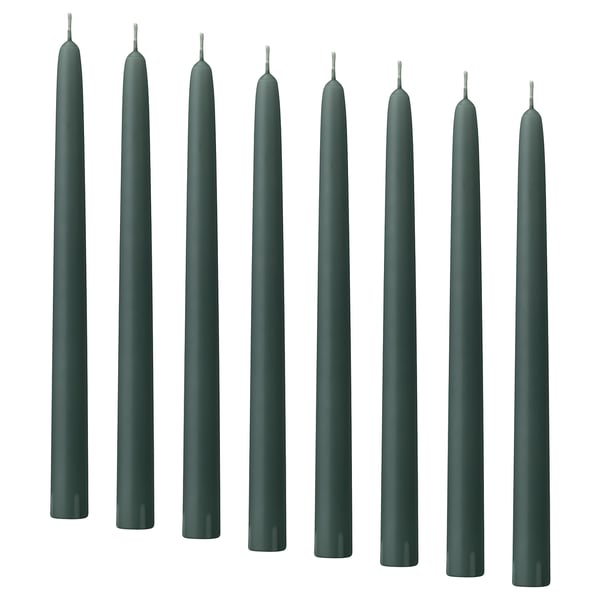 Dark green KLOKHET candles in a row, tall and straight, made of stearin with cotton wicks.