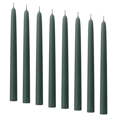 Dark green KLOKHET candles in a row, tall and straight, made of stearin with cotton wicks.