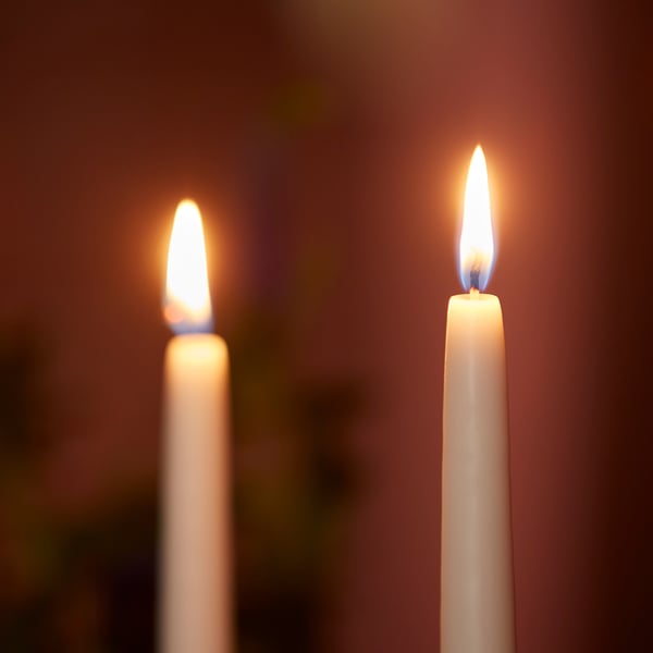 Two lit candles burning steadily and brightly with focused flames.